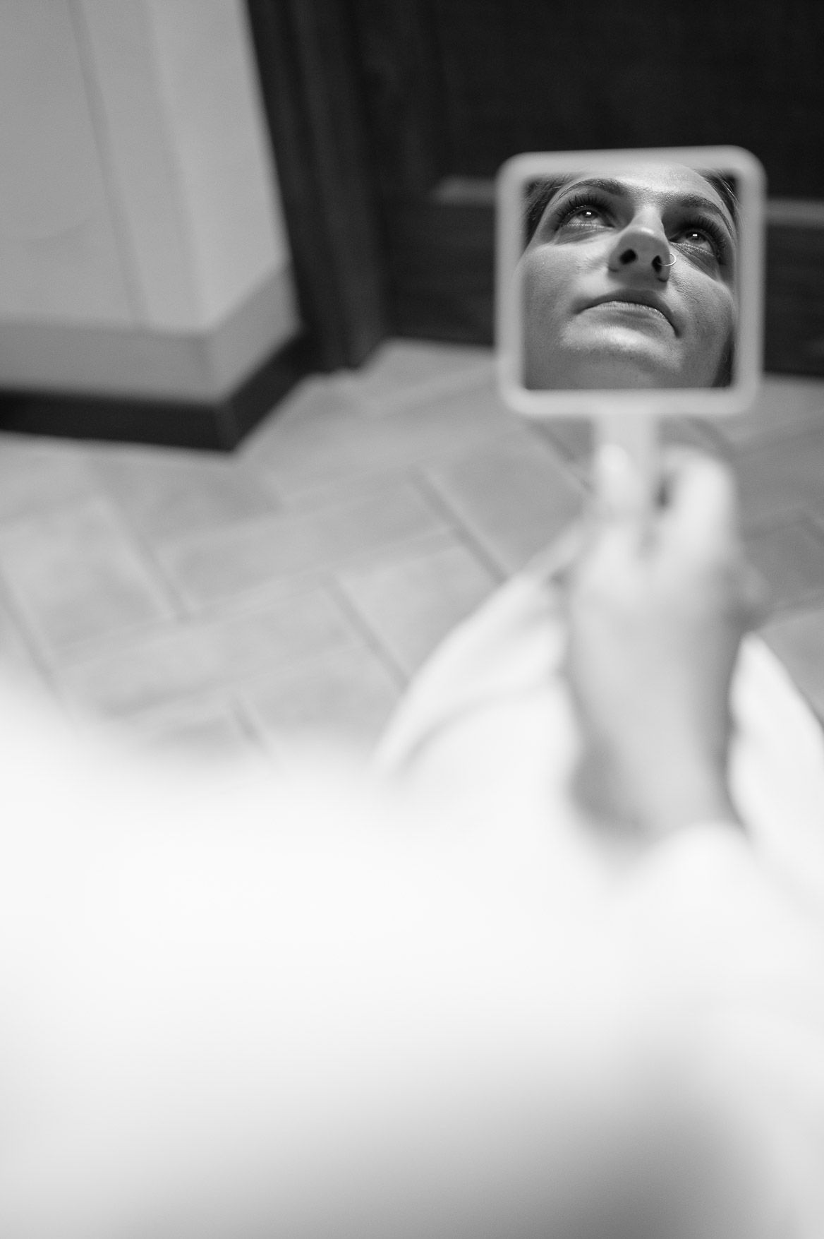 A sequence of black and white photos showing someone looking up at a rearview mirror in a car.
