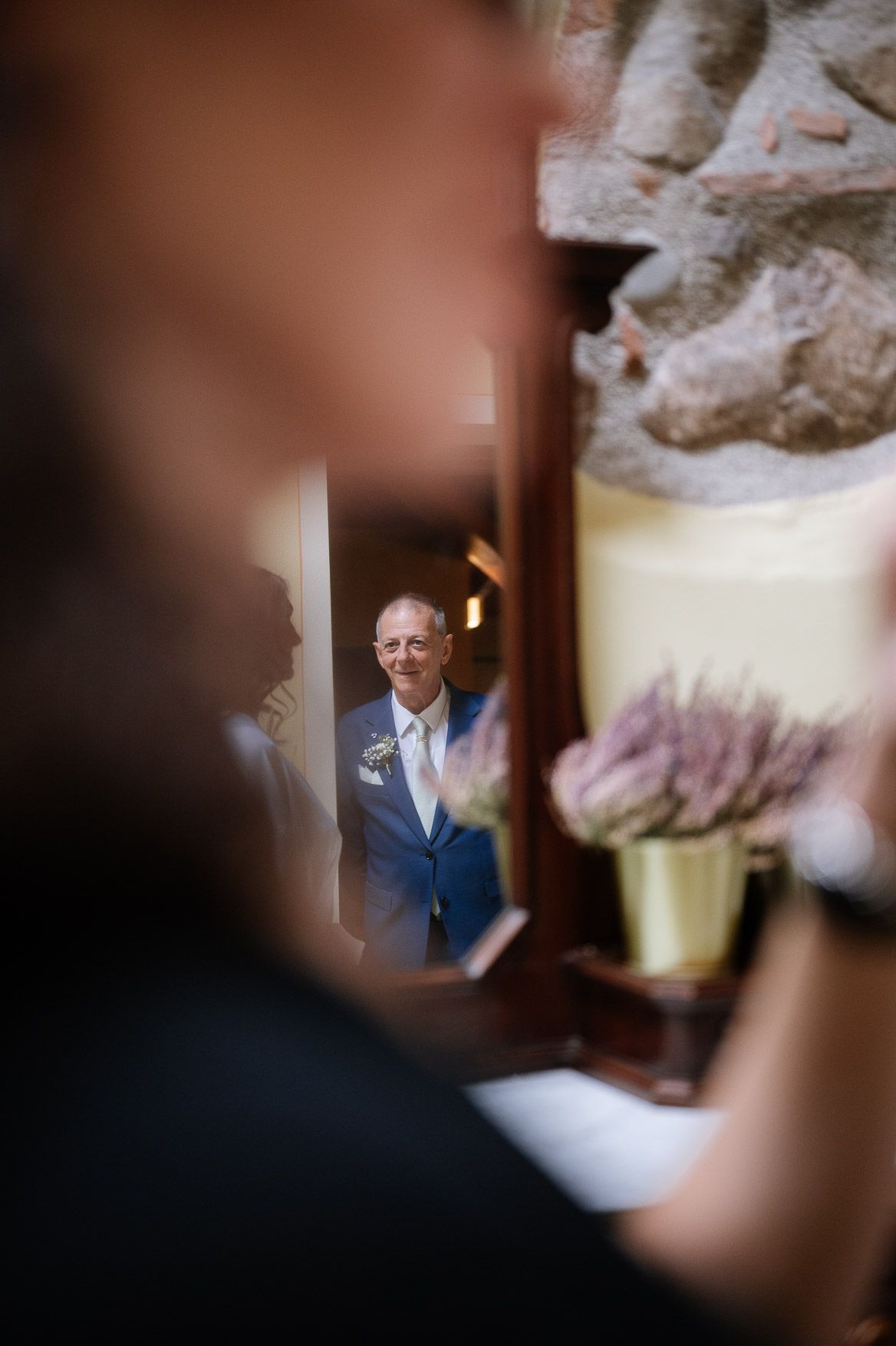 Wedding ceremony candid shots captured through blurred foreground elements creating artistic framing.