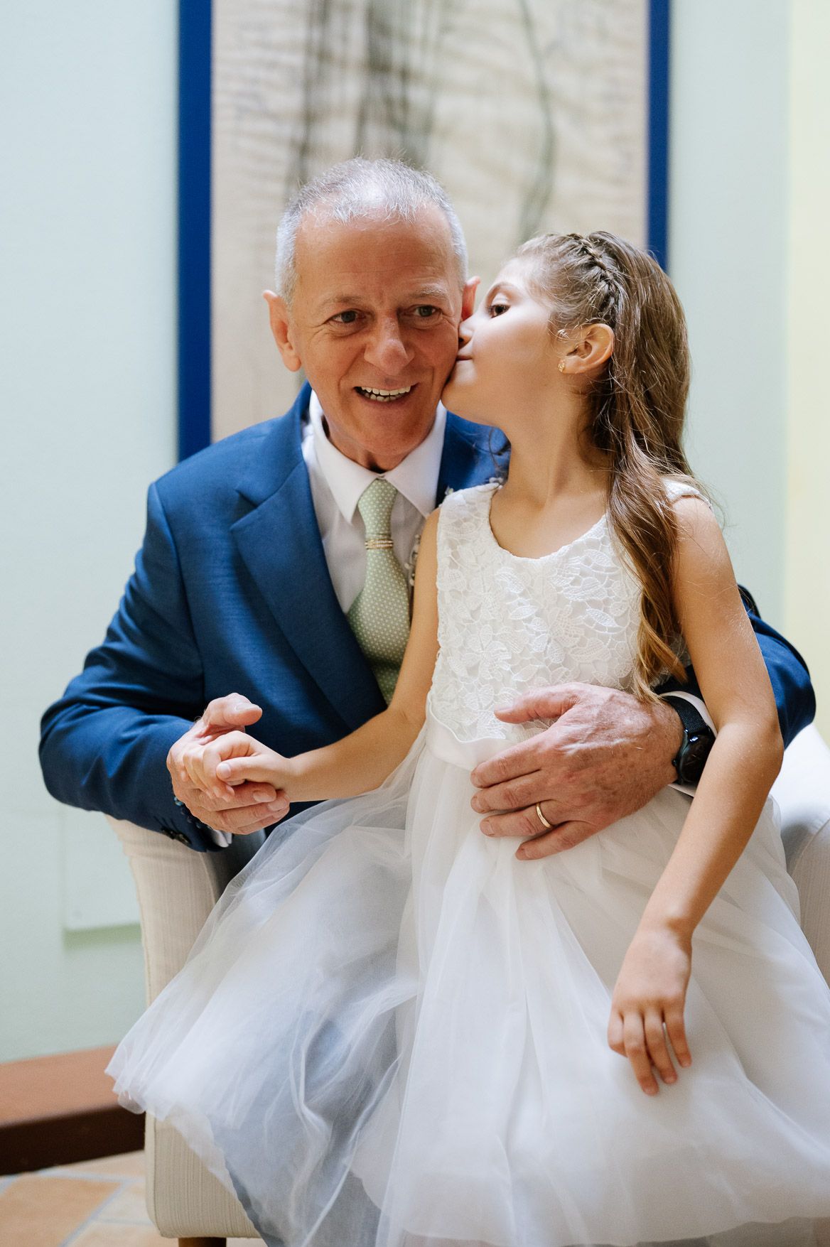 A series of sweet candid moments between a grandfather and granddaughter in formal attire at a special event.