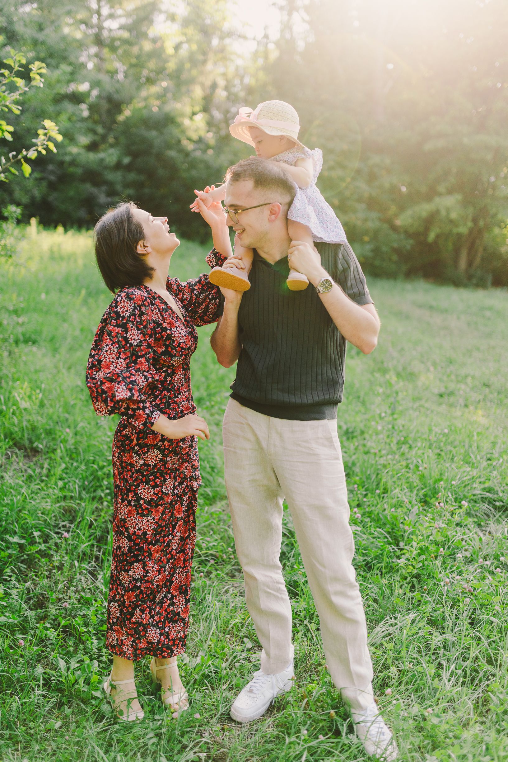 Two people dancing together in a grassy field during golden hour.