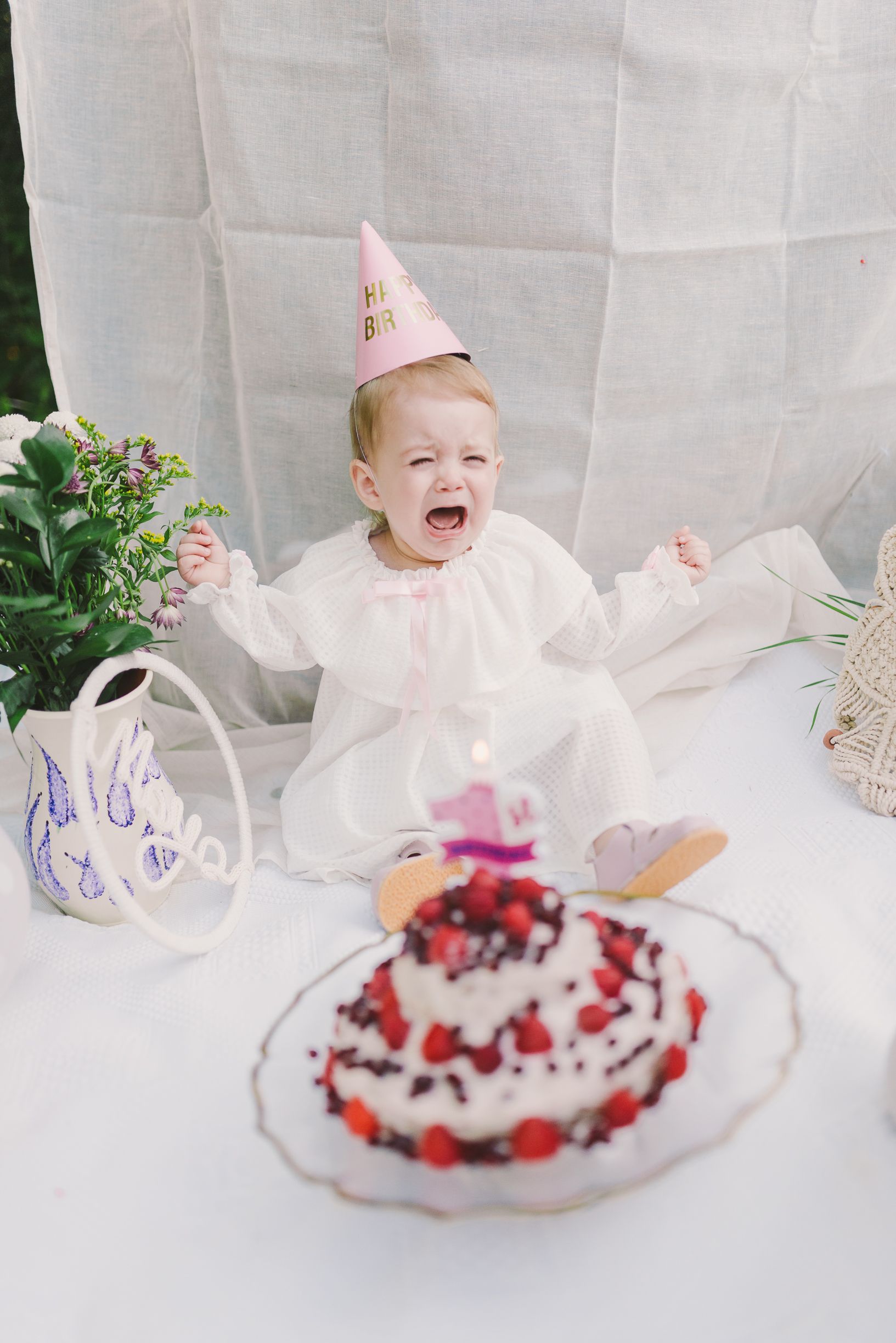 Series of cake smashing photos with a pink birthday hat and frosted dessert.
