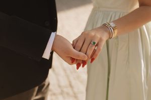 A close-up photo shows hands exchanging wedding rings during a marriage ceremony.