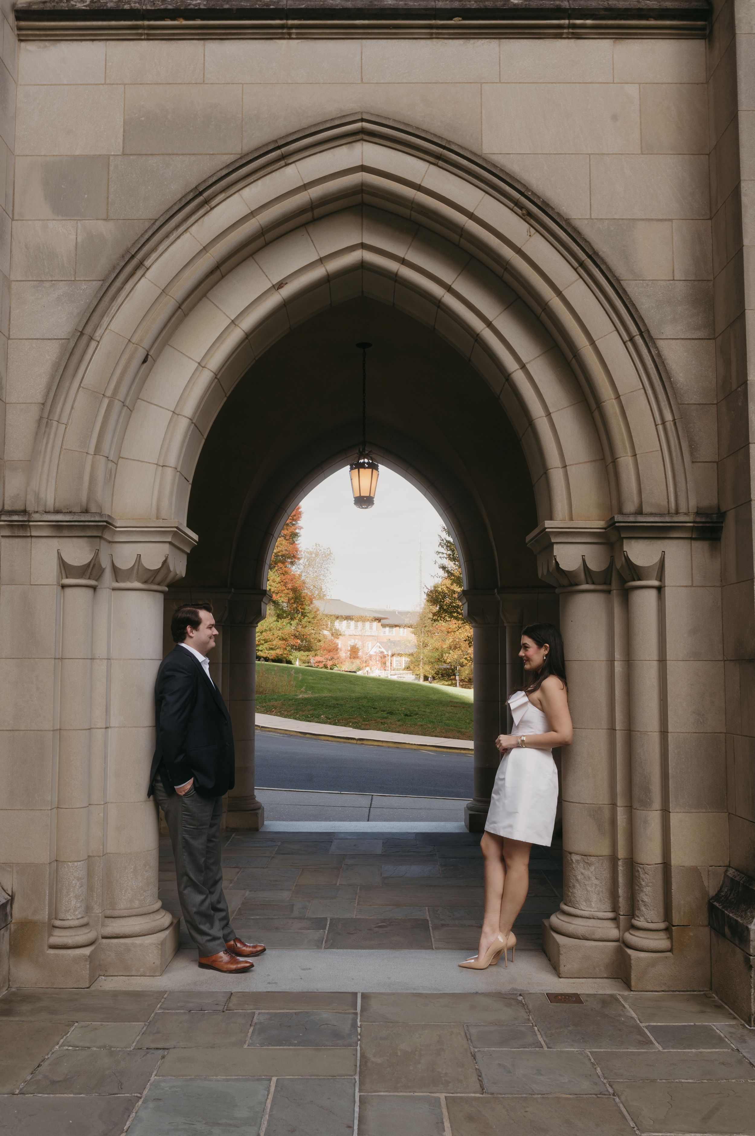 Couple poses in three different romantic shots under a stone archway at sunset.