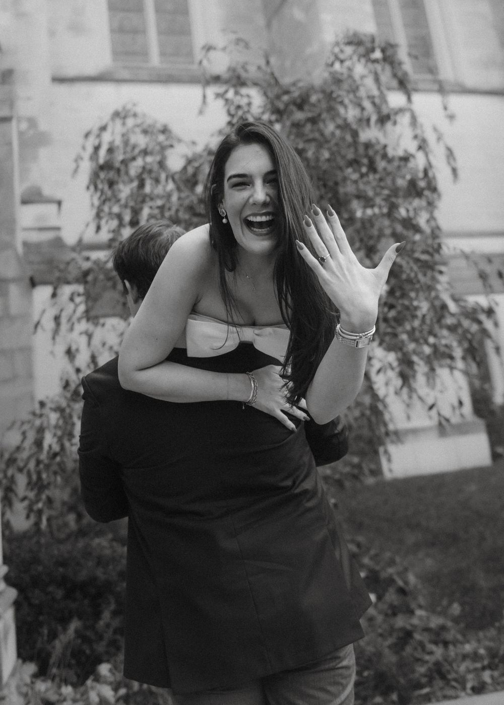 A series of playful black and white photos showing someone in a black dress making expressive poses outdoors.