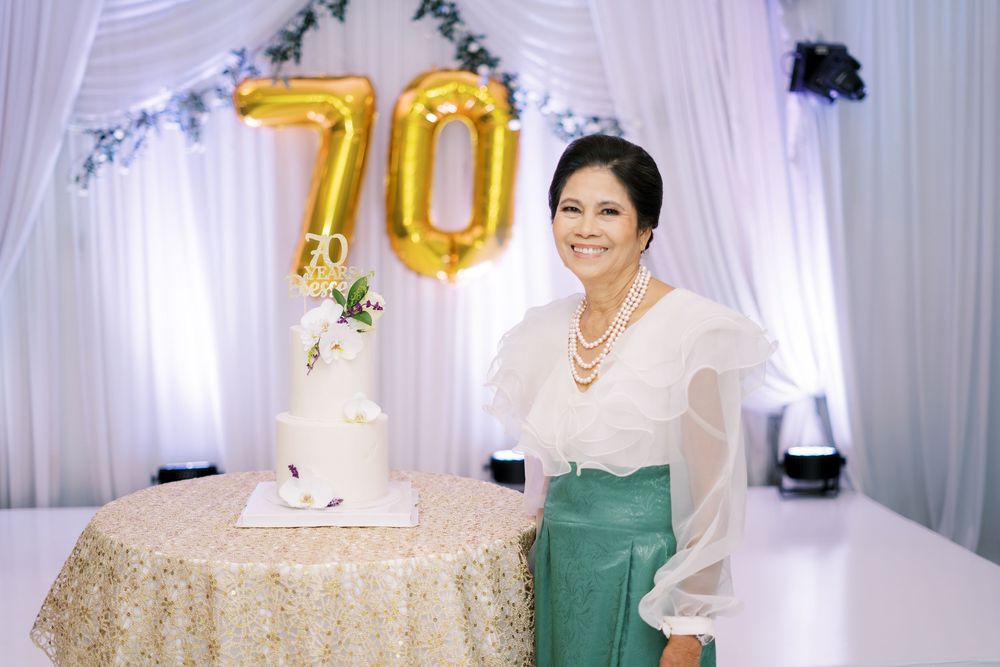 Elegant wedding reception setup with white and gold decor, floral arrangements, and draped fabric creating a romantic atmosphere.