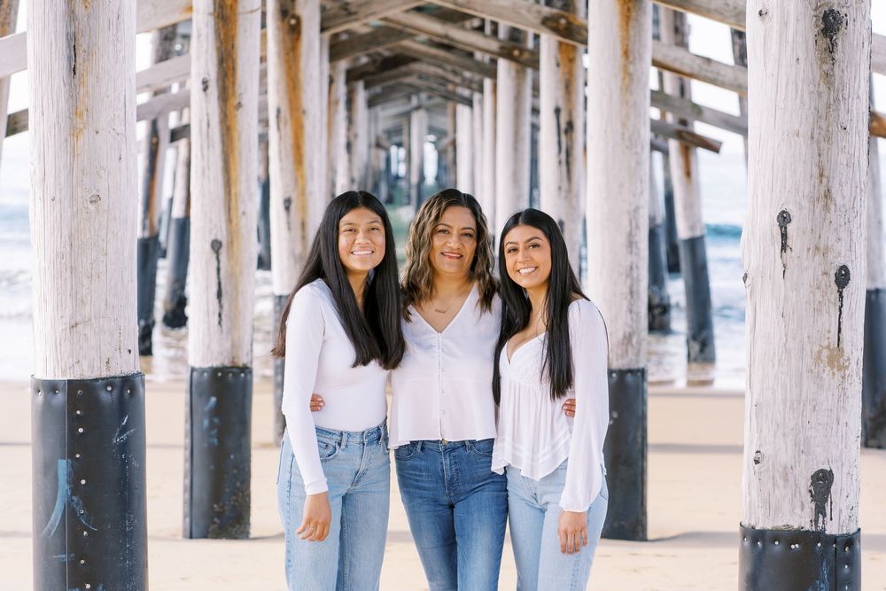 Three people in casual denim outfits pose together against a white background in a lifestyle photoshoot.