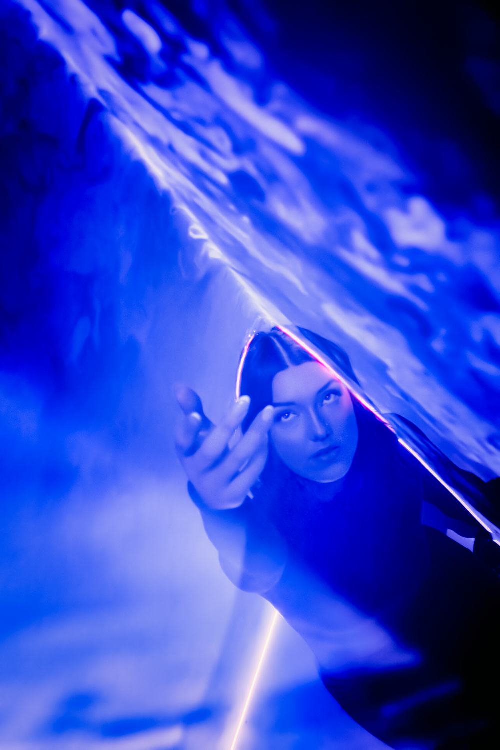 Artistic portrait with dramatic blue lighting and cloudy effects creating an ethereal atmosphere.