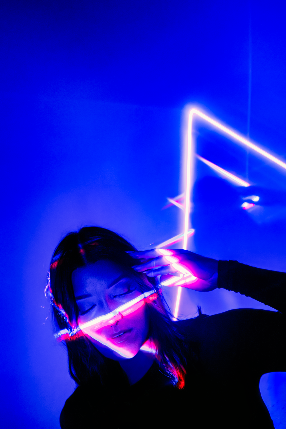Silhouetted figure illuminated by neon blue and pink lights creating a dramatic cyberpunk aesthetic.