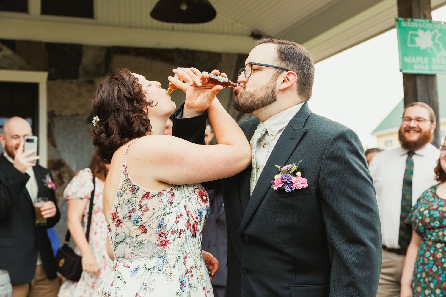 Wedding celebration on a covered porch with guests enjoying drinks and conversation.