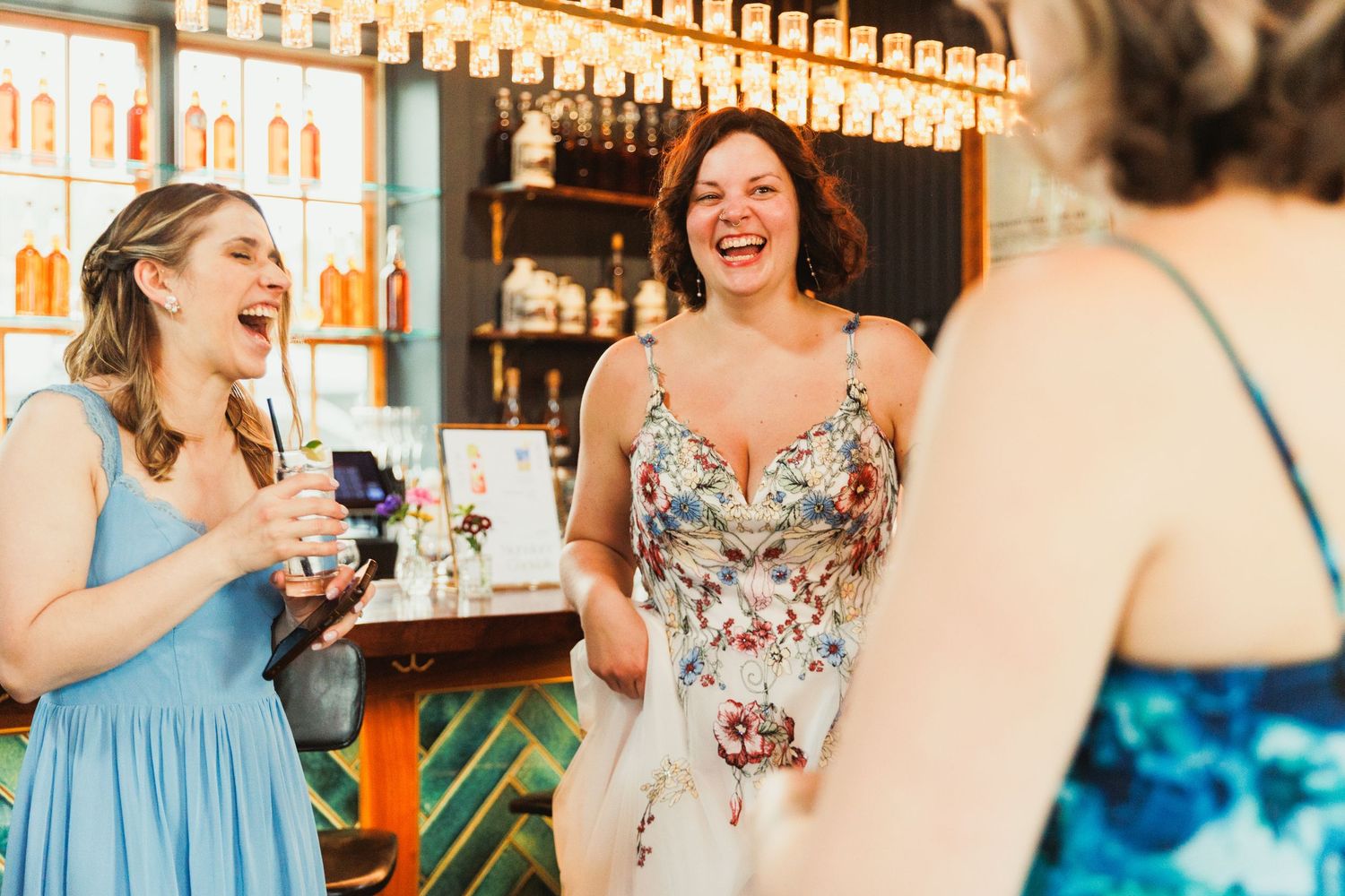 A joyful celebration moment at a bar with drinks and laughter.