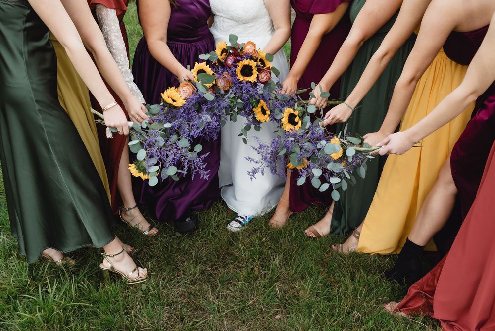 An above eye view of bridesmaids' shoes and bouquets at a fall farmhouse wedding in New Hampshire. Lakes Region wedding photographer
