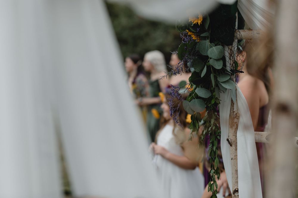An out of focus shot of wedding flowers posted on a white bean during a ceremony in New Hampshire at a farm. Wedding photographer-NH-MA
