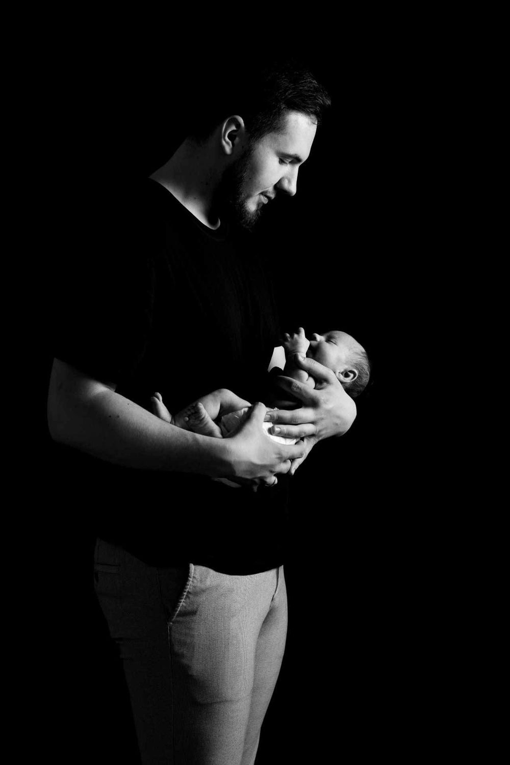 Intimate black and white portrait with dramatic shadows and lighting.