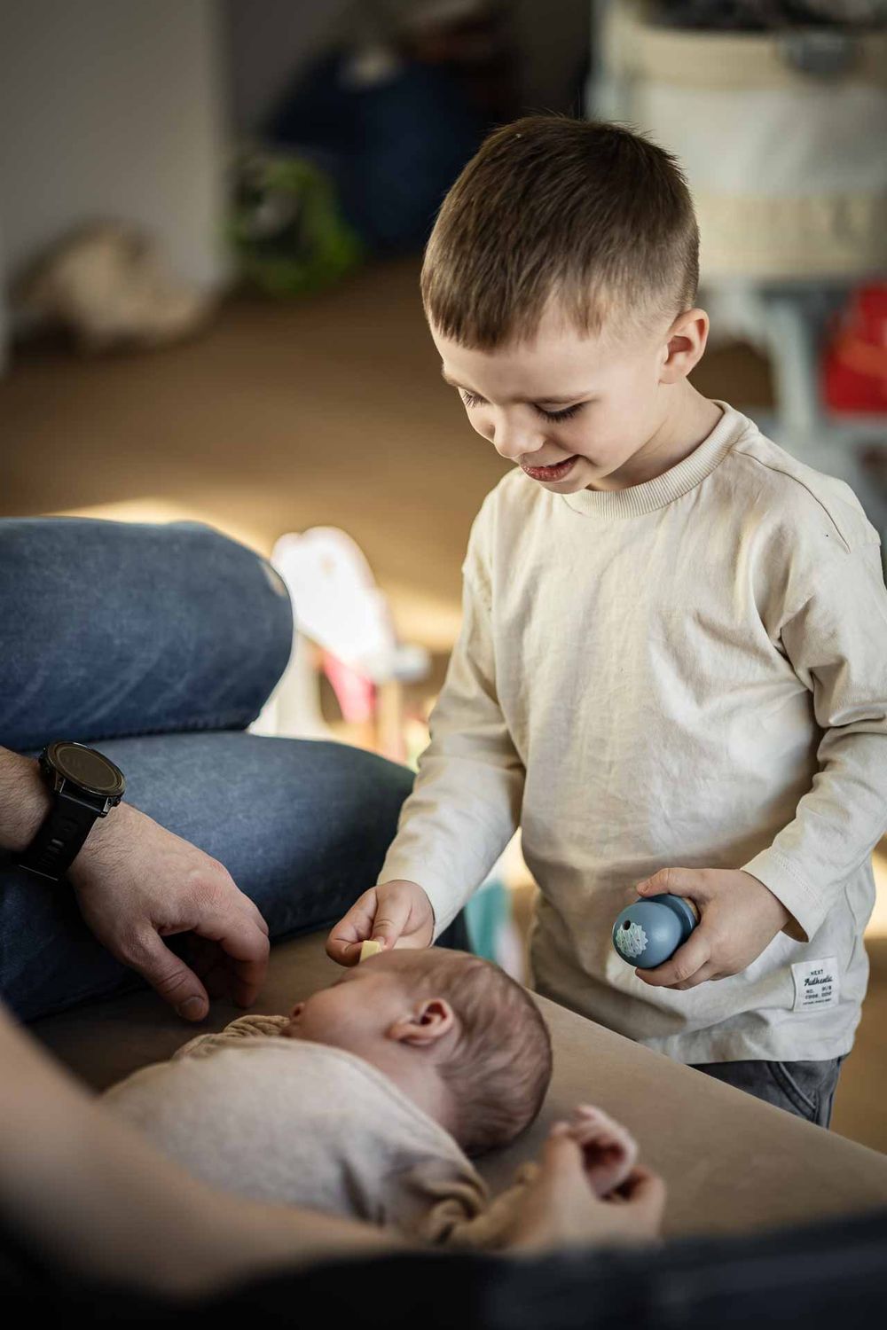 A tender moment between siblings as an older child gently interacts with a baby.