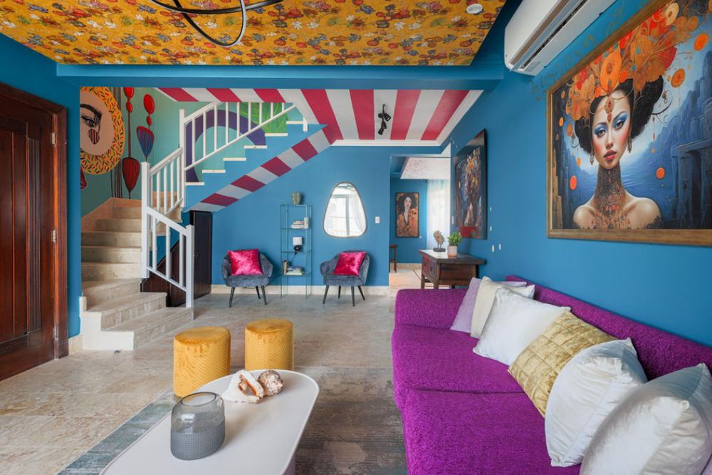 Colorful interior hallway with vibrant blue walls, striped ceiling patterns, and modern furniture in a beach resort. Real State.