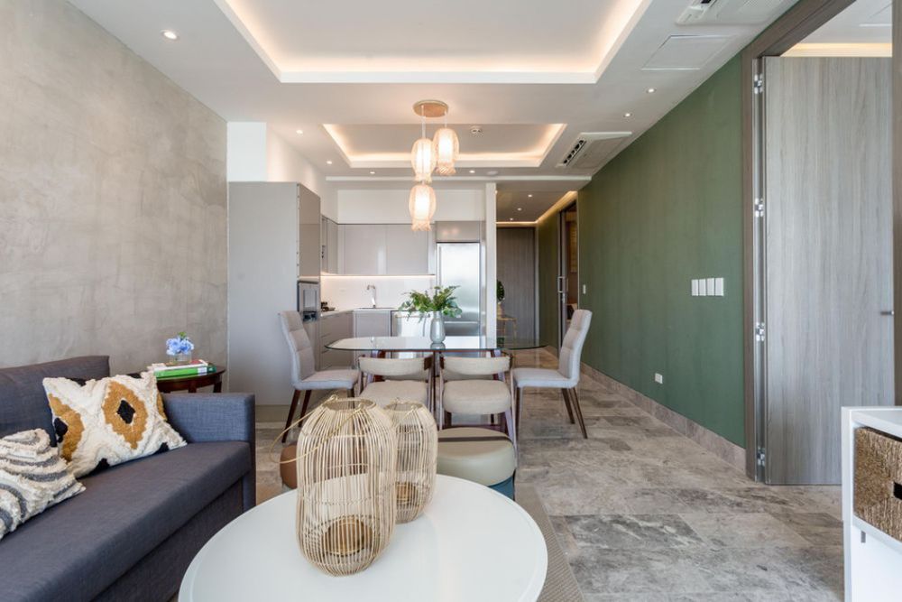 Modern apartment interior with recessed ceiling lighting, white walls, and minimalist furnishings in an open concept layout. Real State.