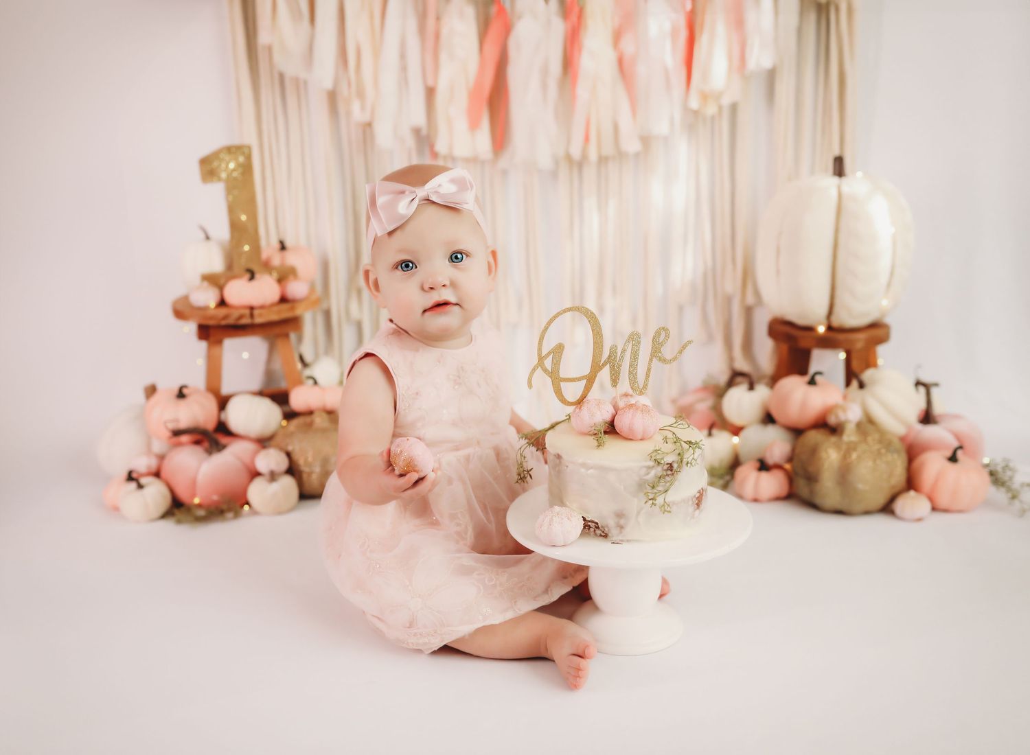 Dreamy pink and white birthday setup with balloons, streamers, and soft lighting creating a magical atmosphere.