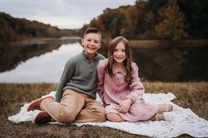 Family portrait session on a blanket during golden hour with fall foliage backdrop.
Best child's photographer in Illinois