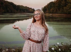 Senior in dress smiling at camera with lake in background. 

Best senior photographer, Peoria, IL.