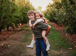 Two children in an apple tree field with one child on the others back smiling at camera

Best  photographer, Peoria, IL.