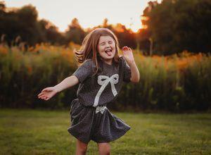 Child making a funny face while she jumps around in a field

Best children's photographer, Peoria, IL.