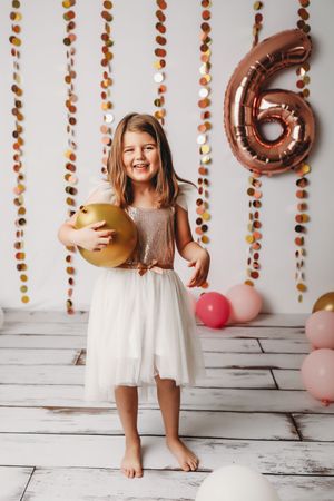Birthday photos with rose gold number balloons and hanging autumn-colored garlands
Best children's photographer, Central Peoria,IL