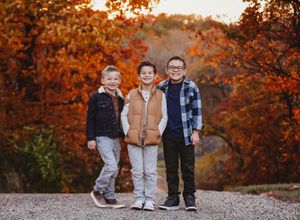 Three young people pose together against a backdrop of vibrant autumn foliage at sunset.

Best child's photographer, IL