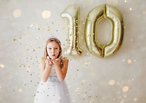 Small child blowing glitter at camera with a ten balloon in the background 

Best child photographer, Peoria, IL.