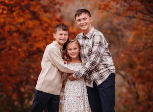 Autumn family photoshoot with vibrant red and orange fall leaves in background.
Best child's photographer.