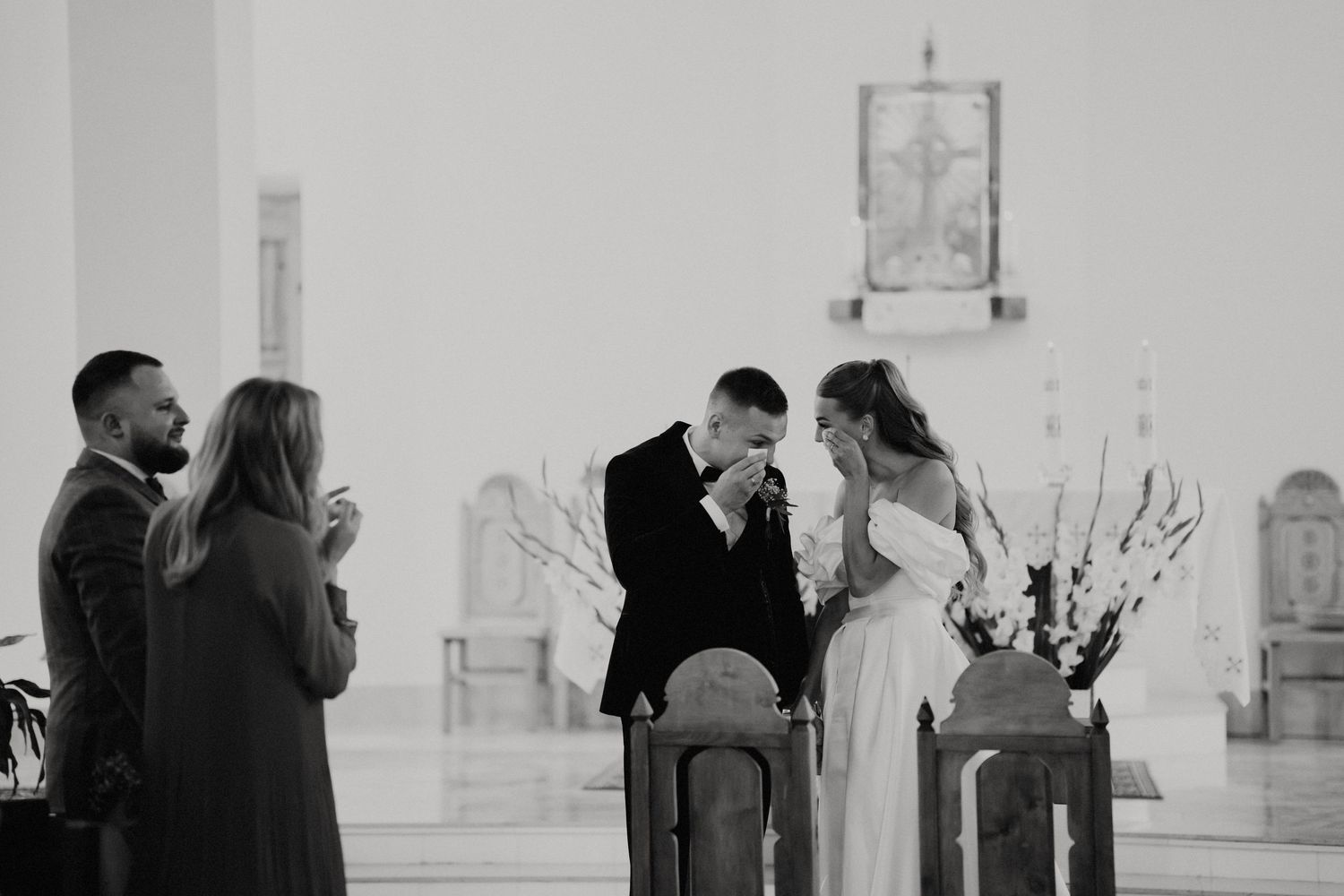 Wedding couple shares tender moments in a bright minimalist white interior space.