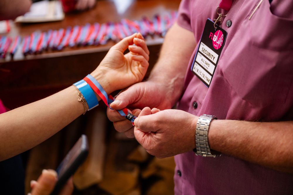 Event staff member checking wristband or registration details during check-in process.