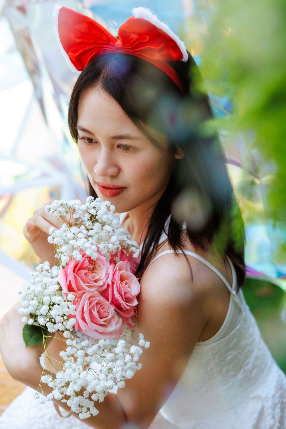 Romantic portrait with pink roses and baby's breath bouquet against natural garden backdrop.