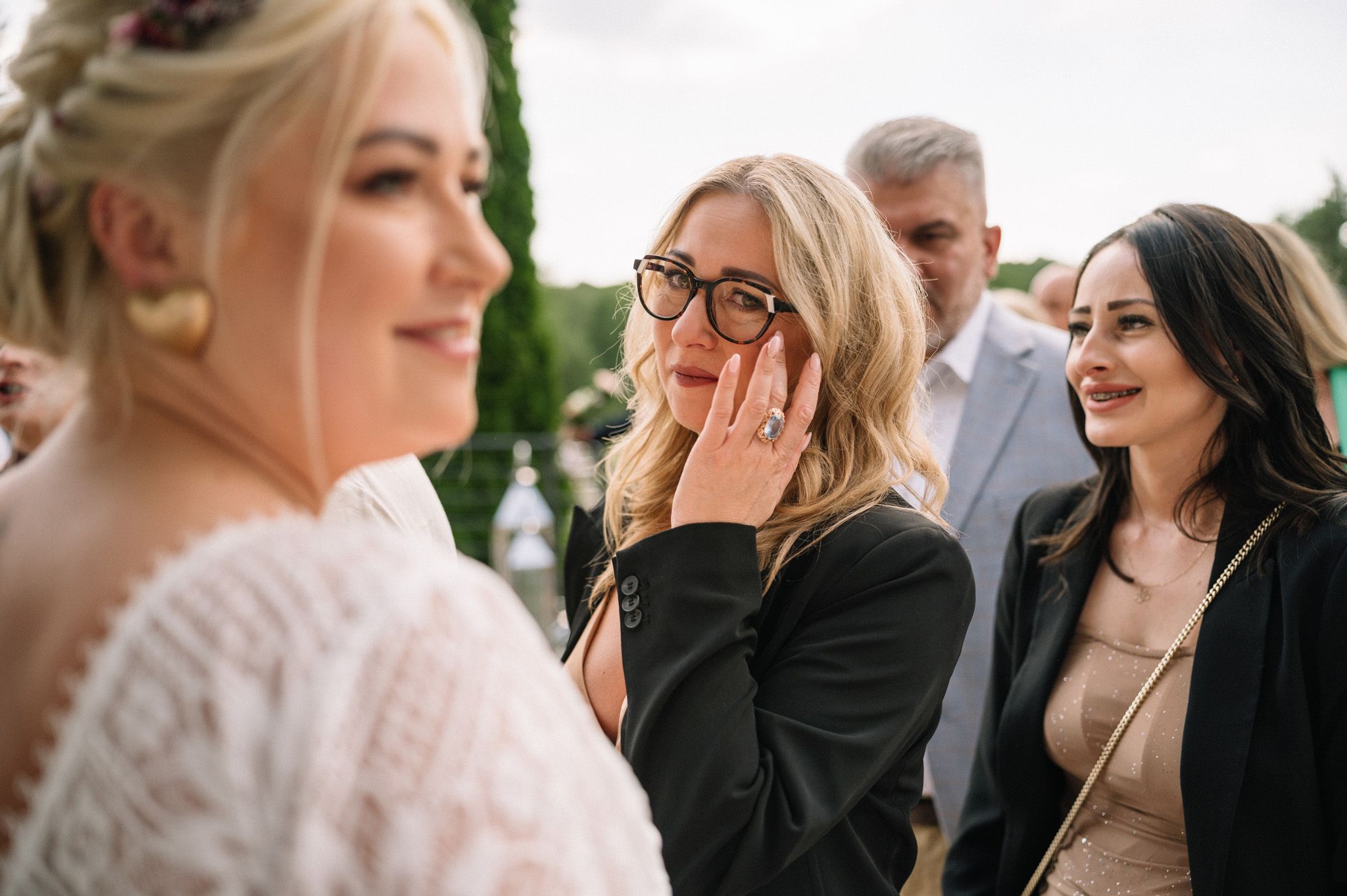 Emotional reactions during a wedding celebration outdoors.