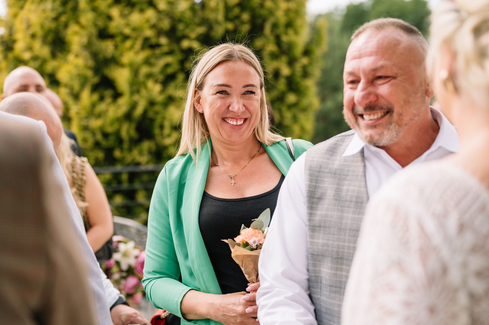 Guests sharing laughs during an outdoor wedding celebration.
