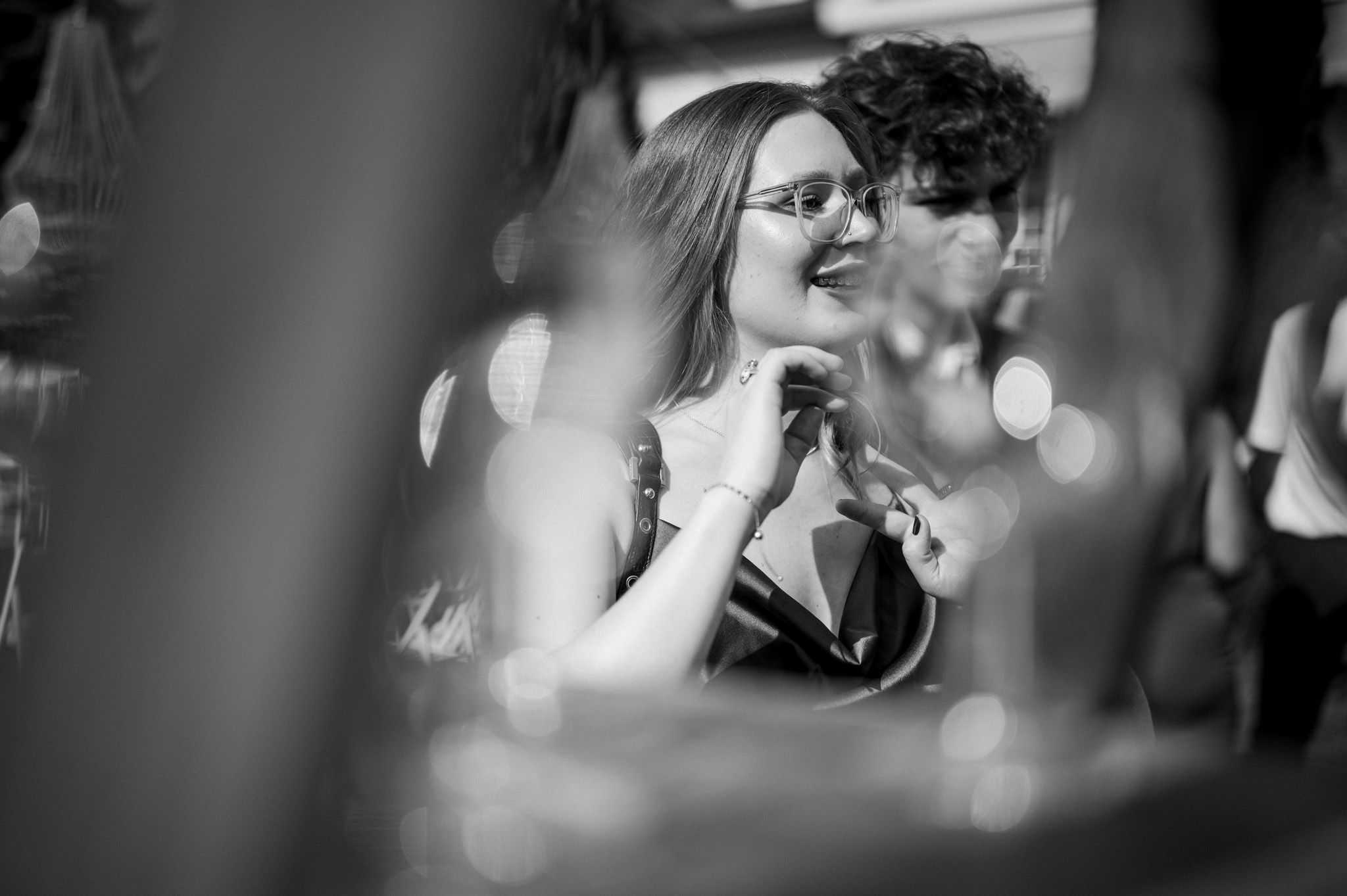 Black and white candid shot of guests enjoying intimate conversation at celebration.