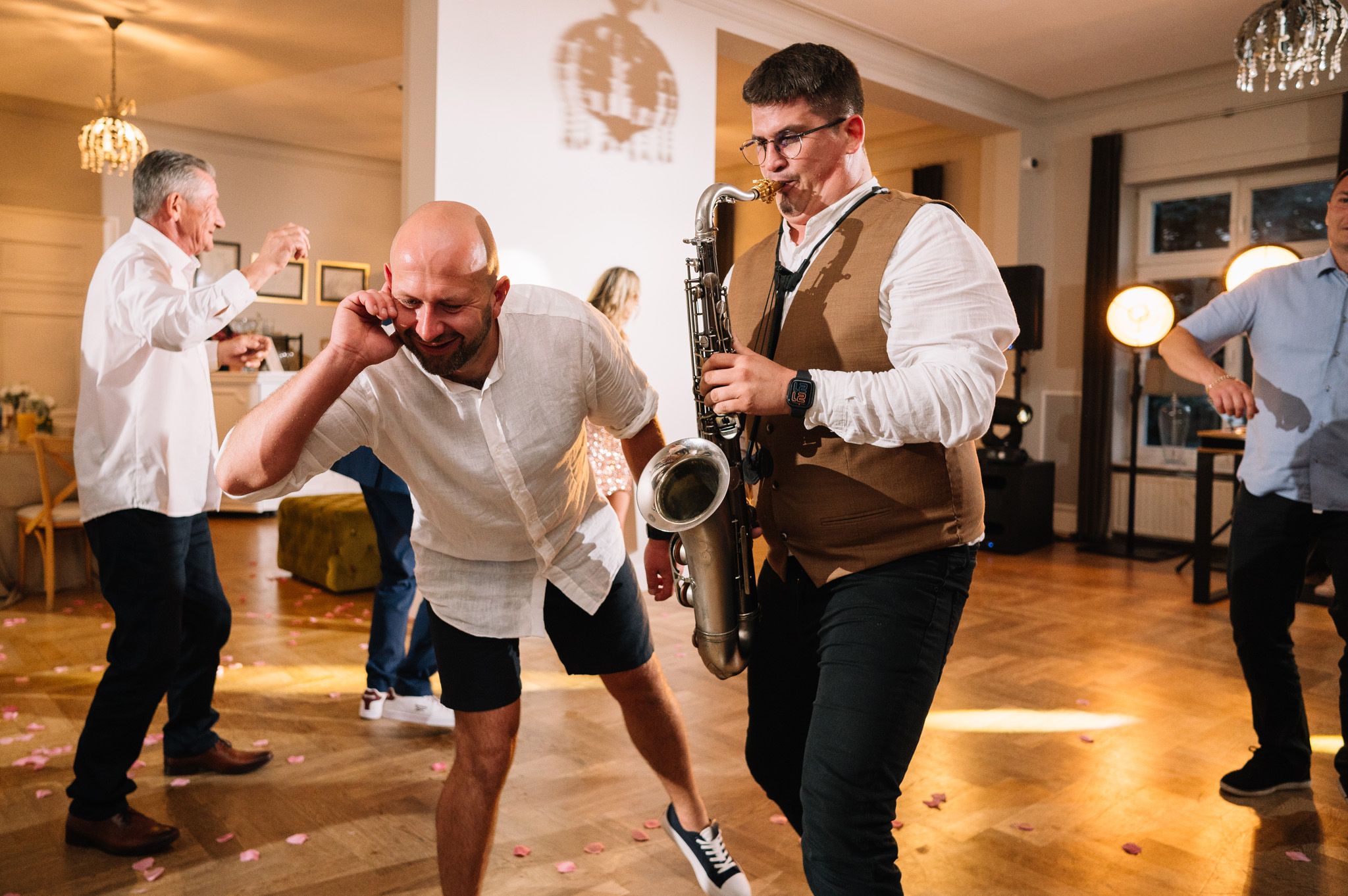 Musicians and dancers create lively atmosphere during indoor celebration.