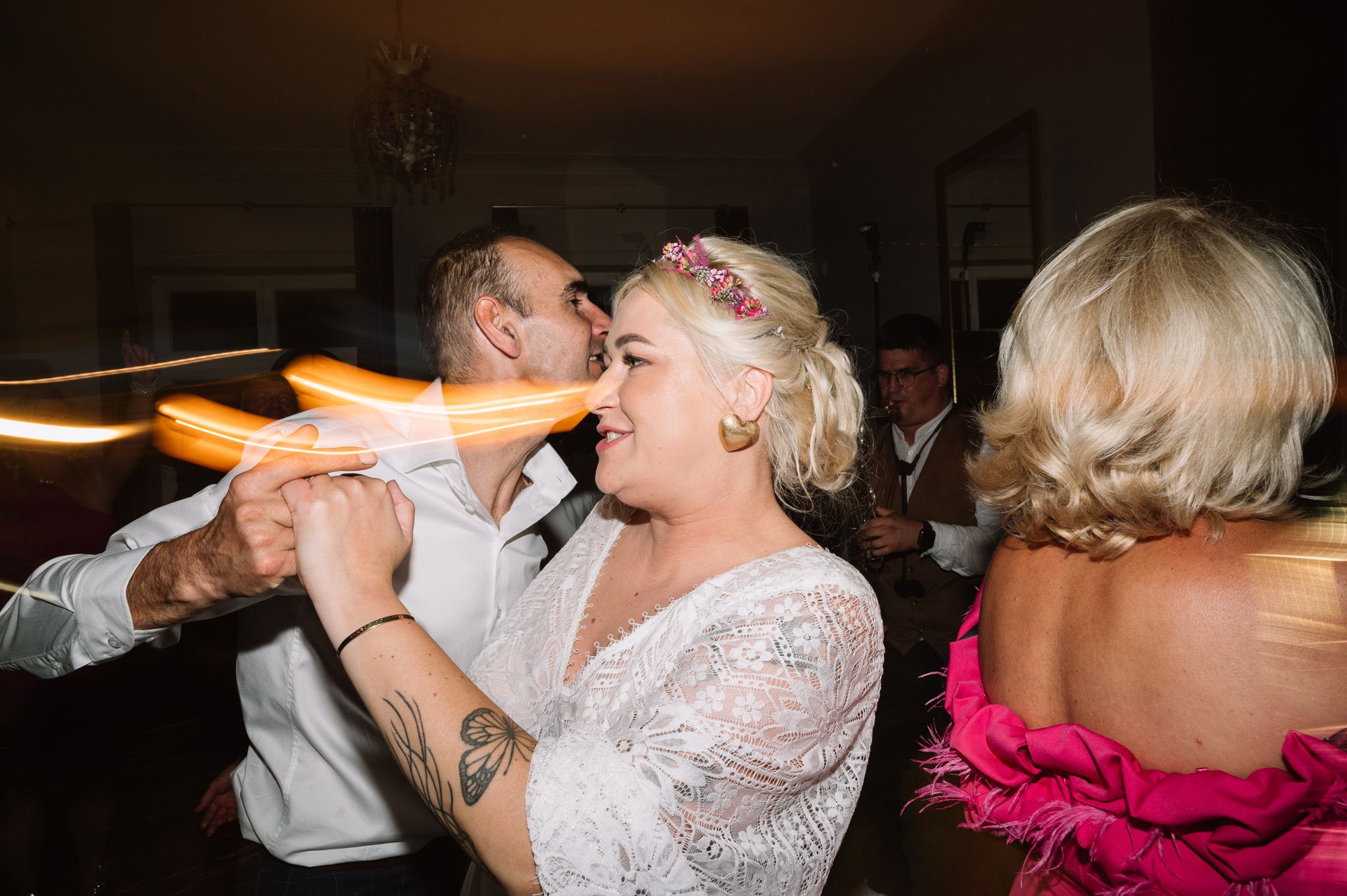 Lively dance floor scene at a wedding reception with guests dancing under warm lighting.