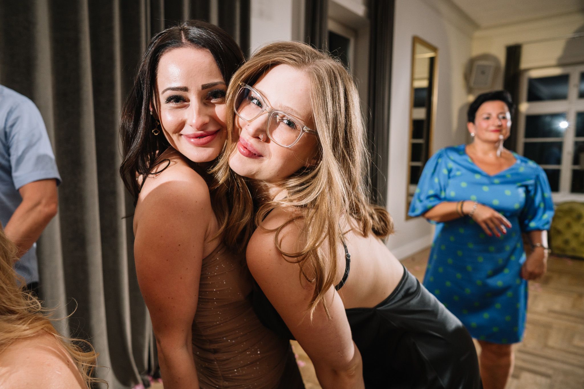 Party guests pose and smile during a celebratory gathering in an indoor venue.