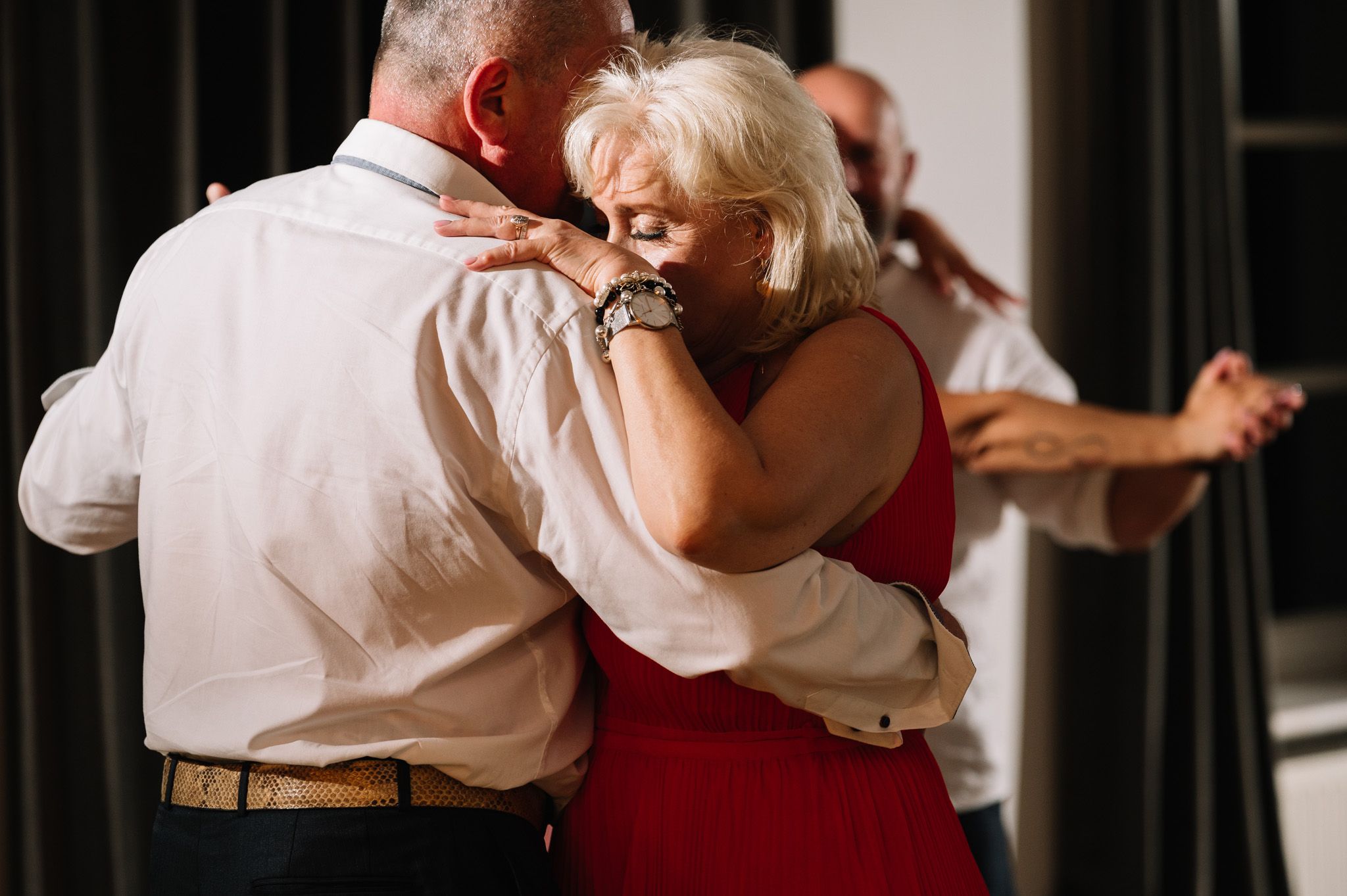 Couple sharing an intimate slow dance embrace at an evening celebration.