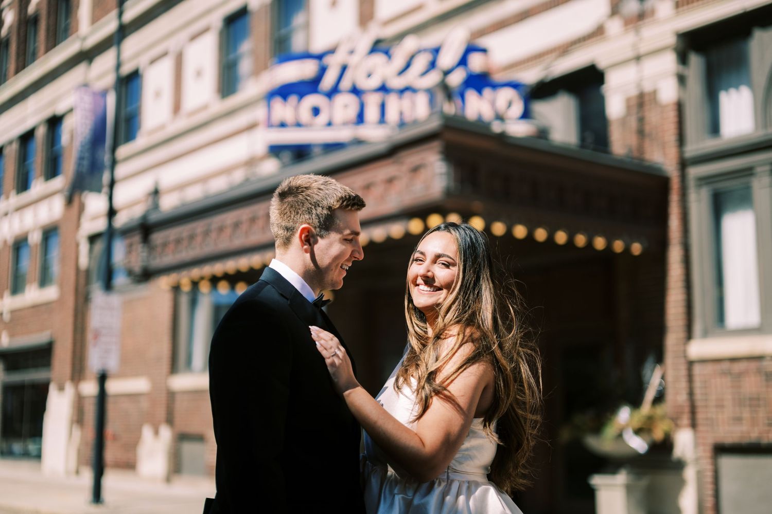 A joyful couple shares a romantic moment together on the street in front of an urban storefront.