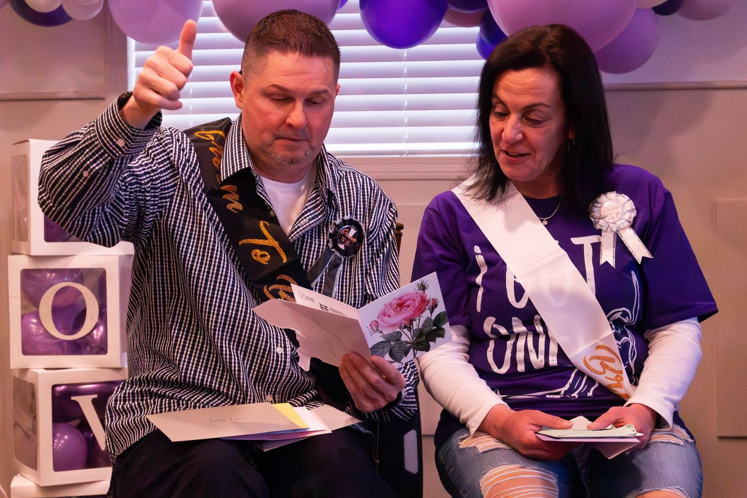 Two people celebrating with drinks and decorations at what appears to be a baby shower.