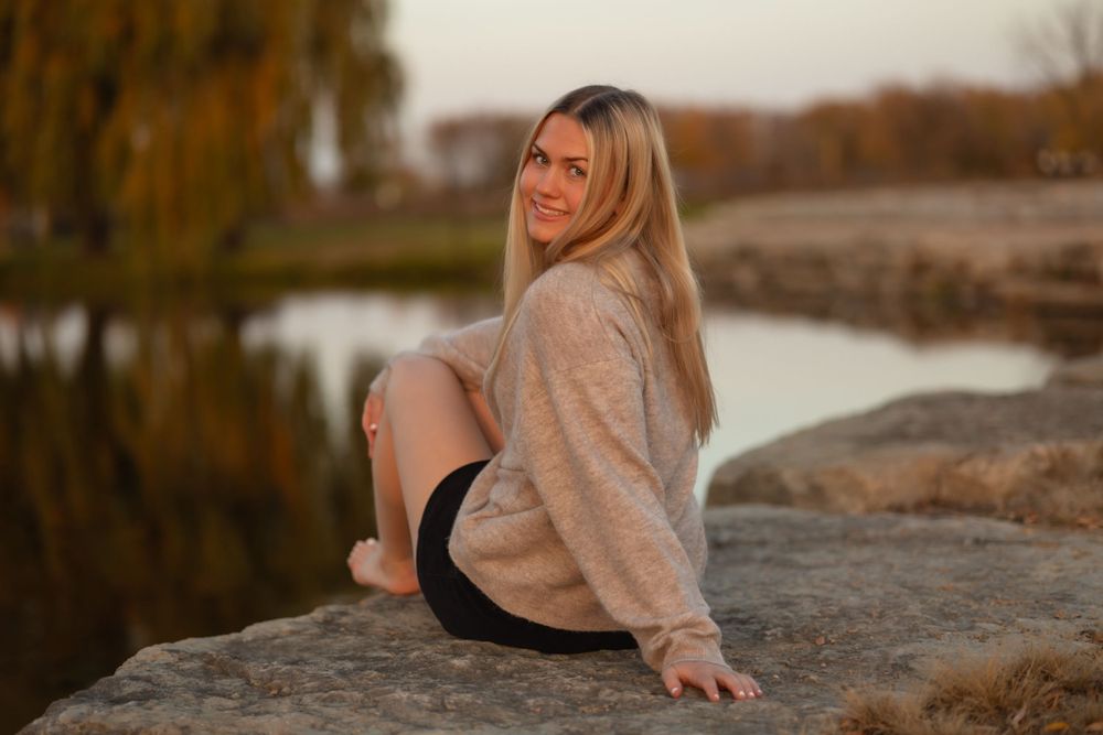 Portrait on rocky shoreline during sunset in autumn.