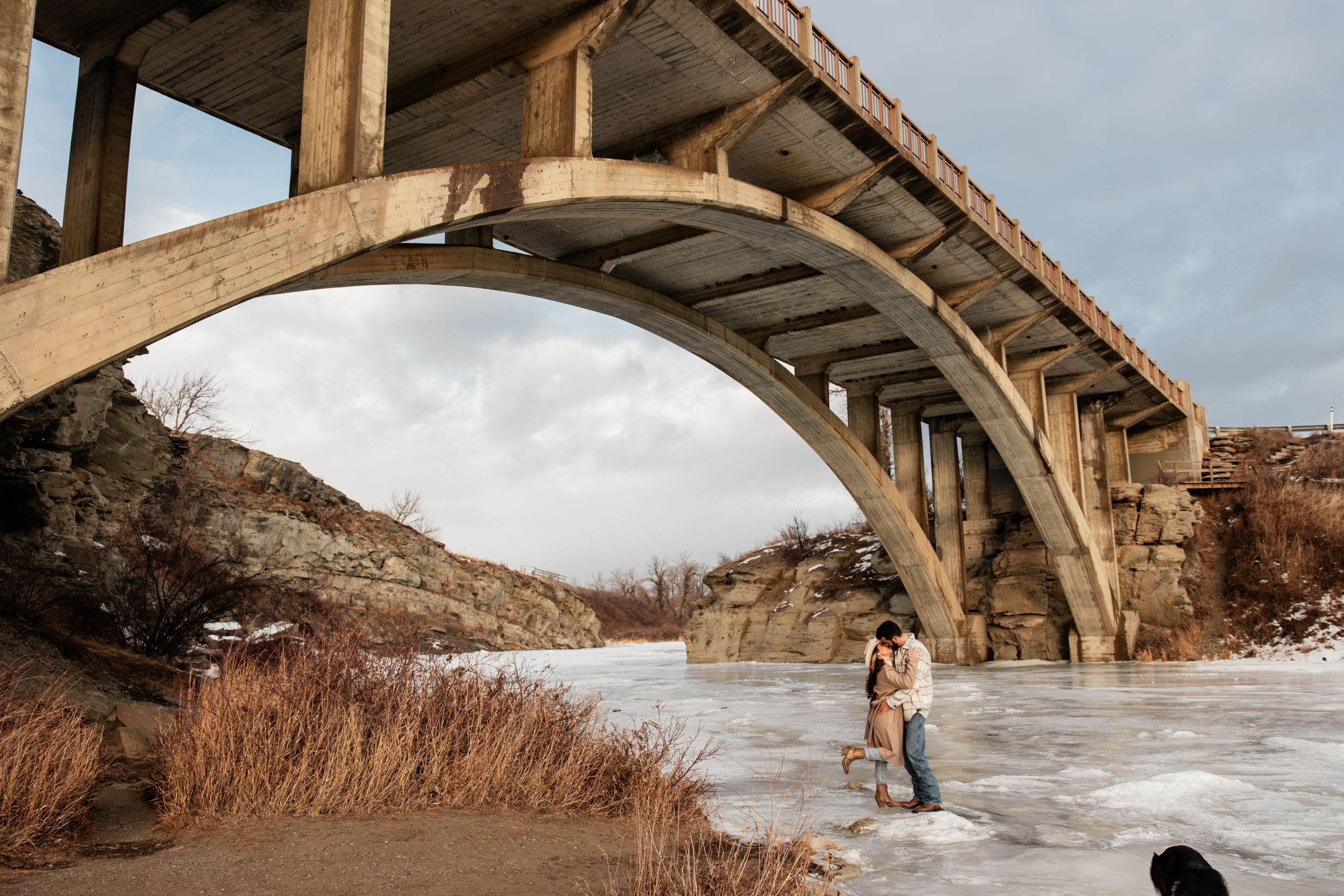 couple kissing under bridge