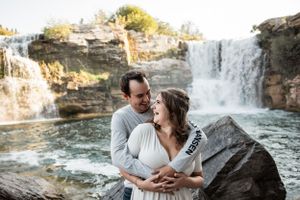 couple laughing with beautiful waterfall behind