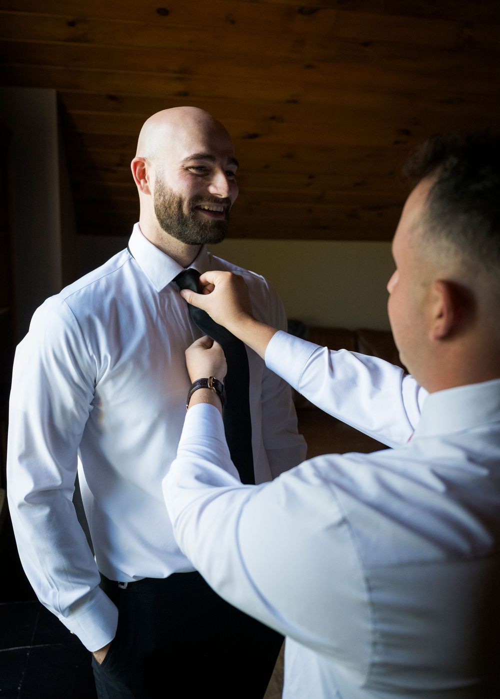Sequence showing the adjustment of a tie in dramatic indoor lighting.