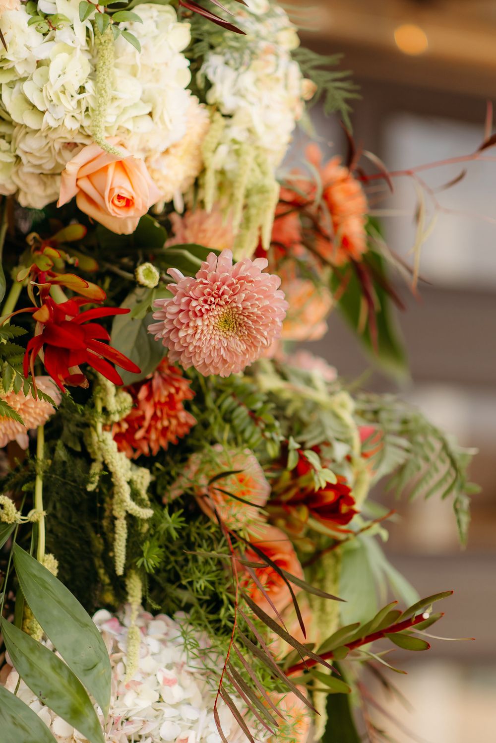 Lush floral arrangement featuring hydrangeas, roses, and pink dahlias with greenery.