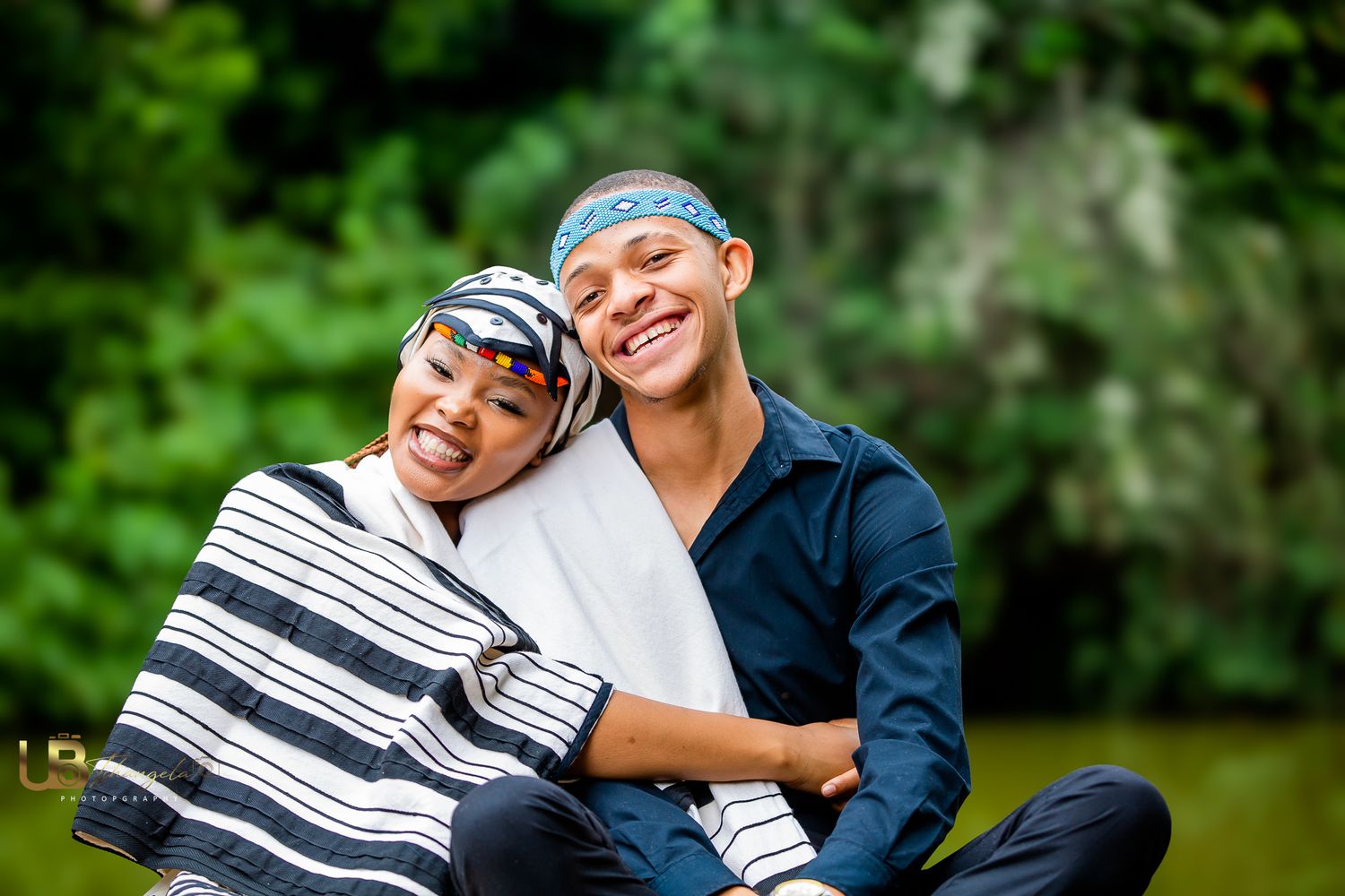 Couple sitting down next to the river.