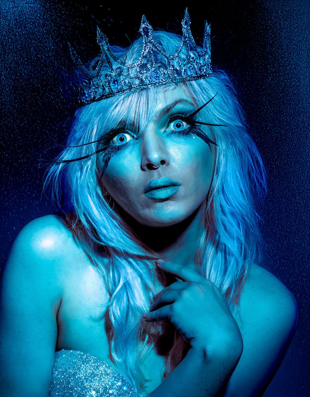 Fantasy portrait with ice crown and blue lighting creating ethereal winter queen effect.