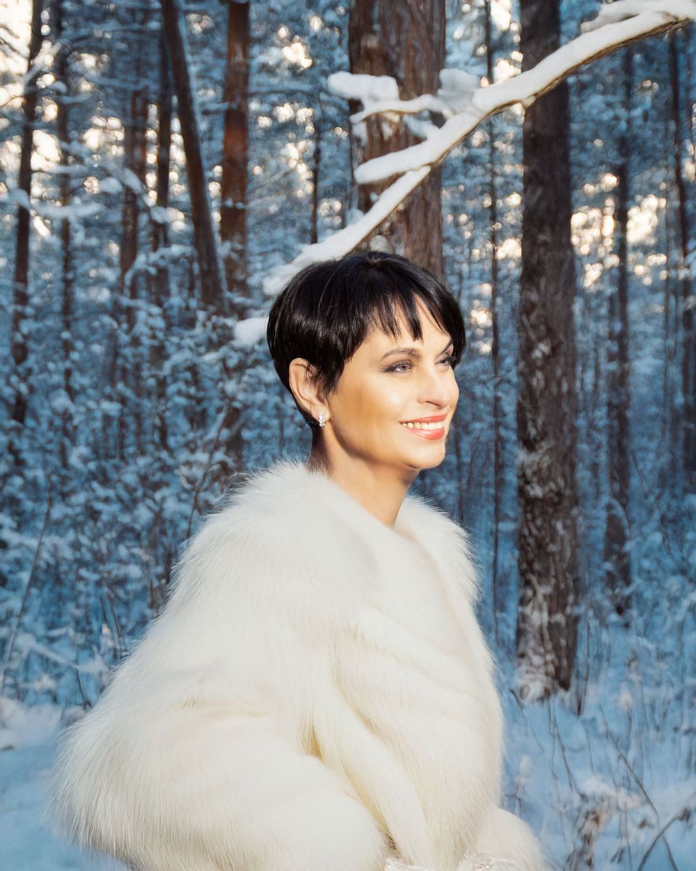 A winter portrait in a snowy forest featuring a person wearing a cozy white fur coat.