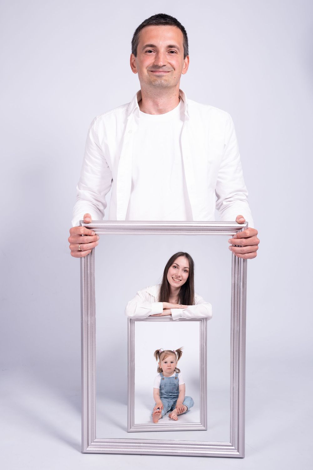 Creative portrait photo composition with stacked frames showing family members in white attire against gray background.